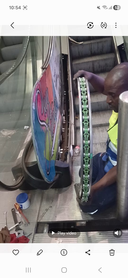 Technician repairing escalator chain drive